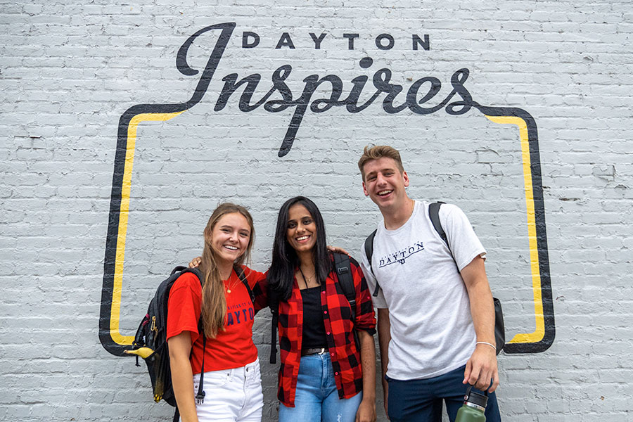 students in front of a Dayton Inspires mural
