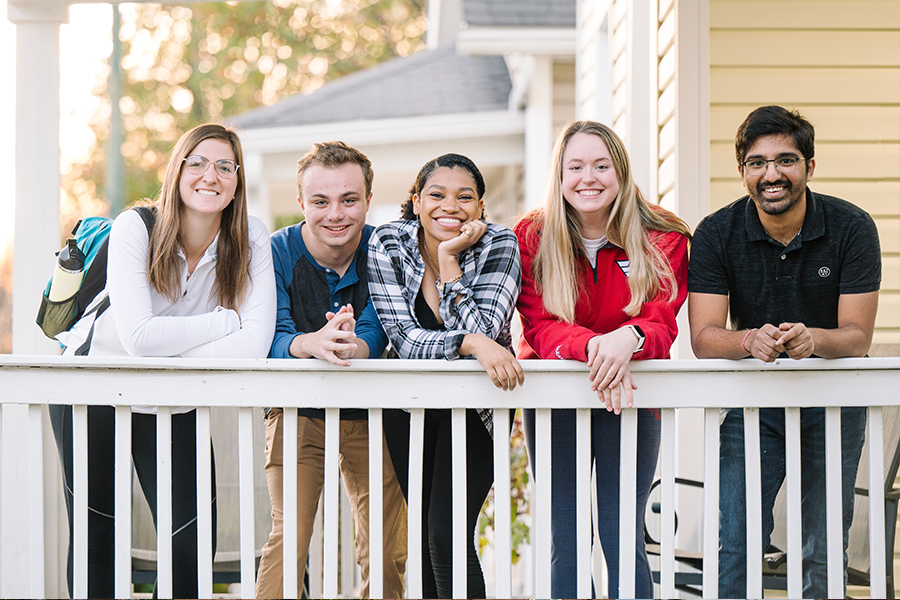 ${ 5 smiling students on porch }