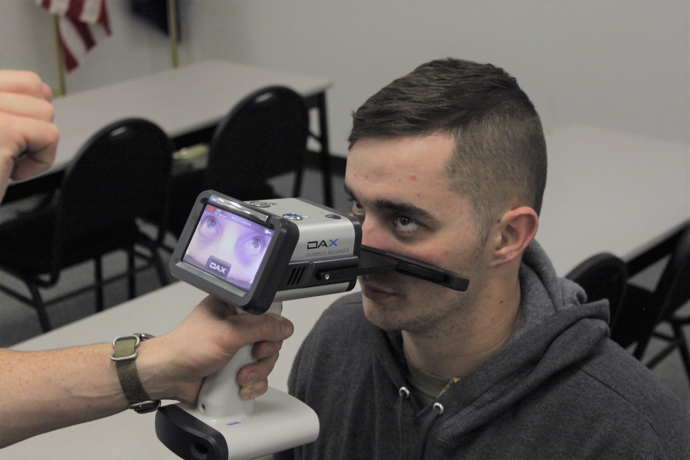Testing DAX recorder. Recorder is placed on face below the eyes of the person. It has a small screen that the officer can view the recording on.