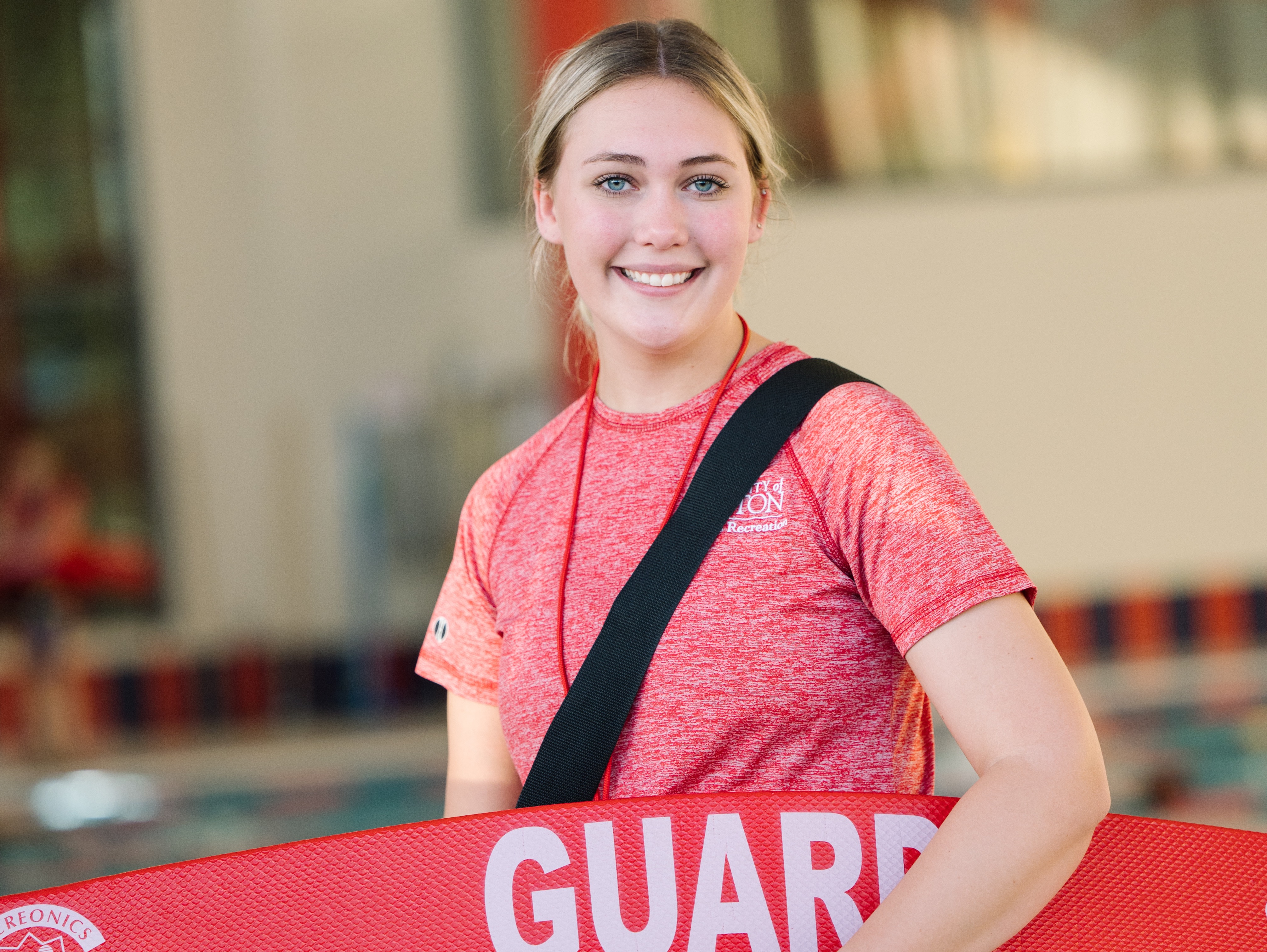 ${ A student worker in the aquatics center working as a lifeguard, with their appropriate attire and gear at hand. }