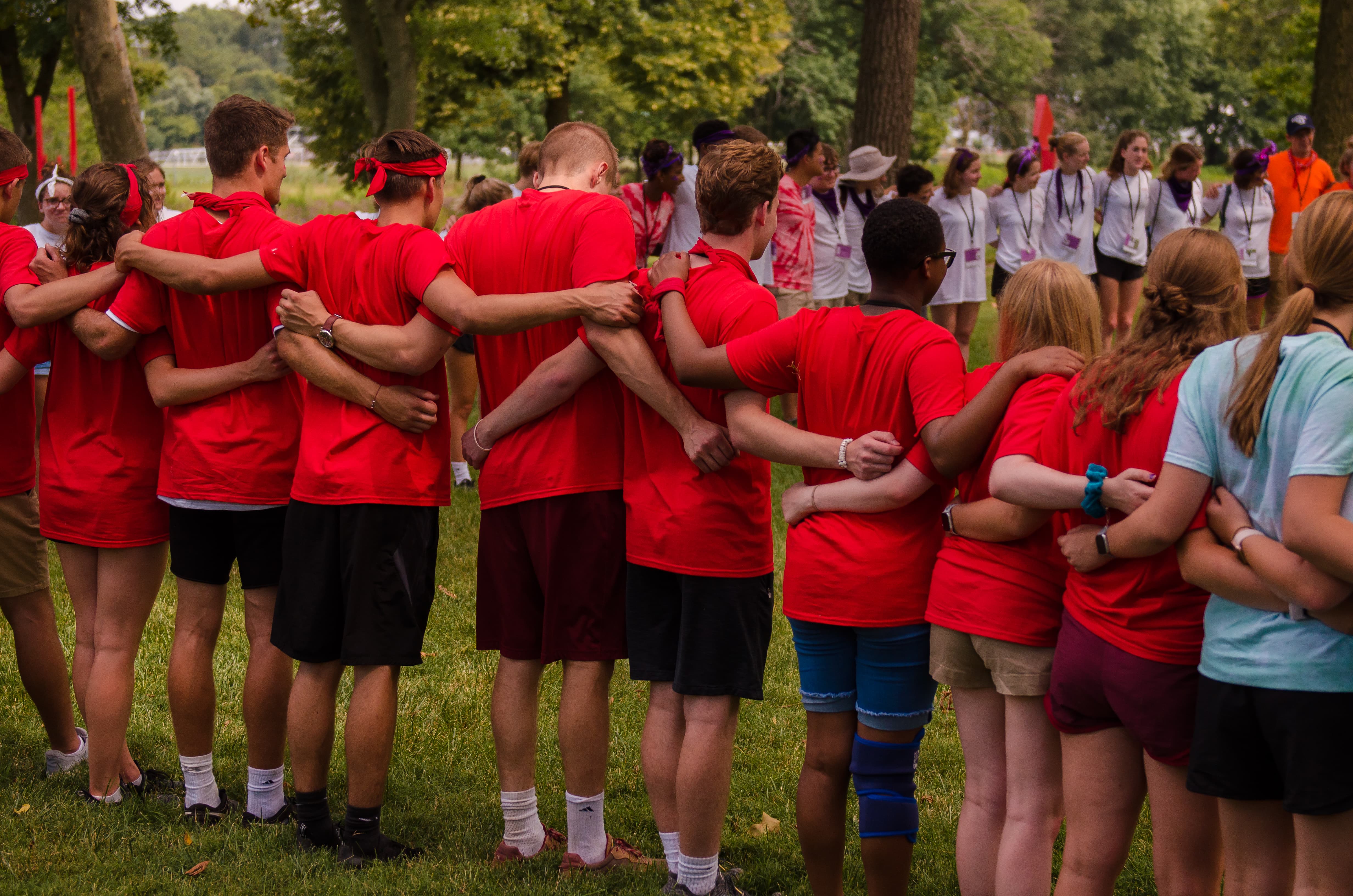 A group of students with their arms around one another at an outdoor student activity